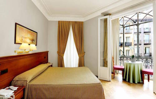gold and white hotel room inside Hostal La Macarena